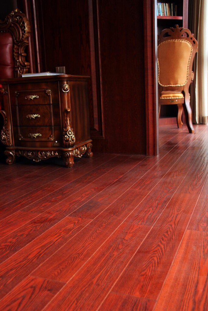 Luxury Vinyl Plank flooring with a warm red hue and realistic wood grain, durable and waterproof for busy households